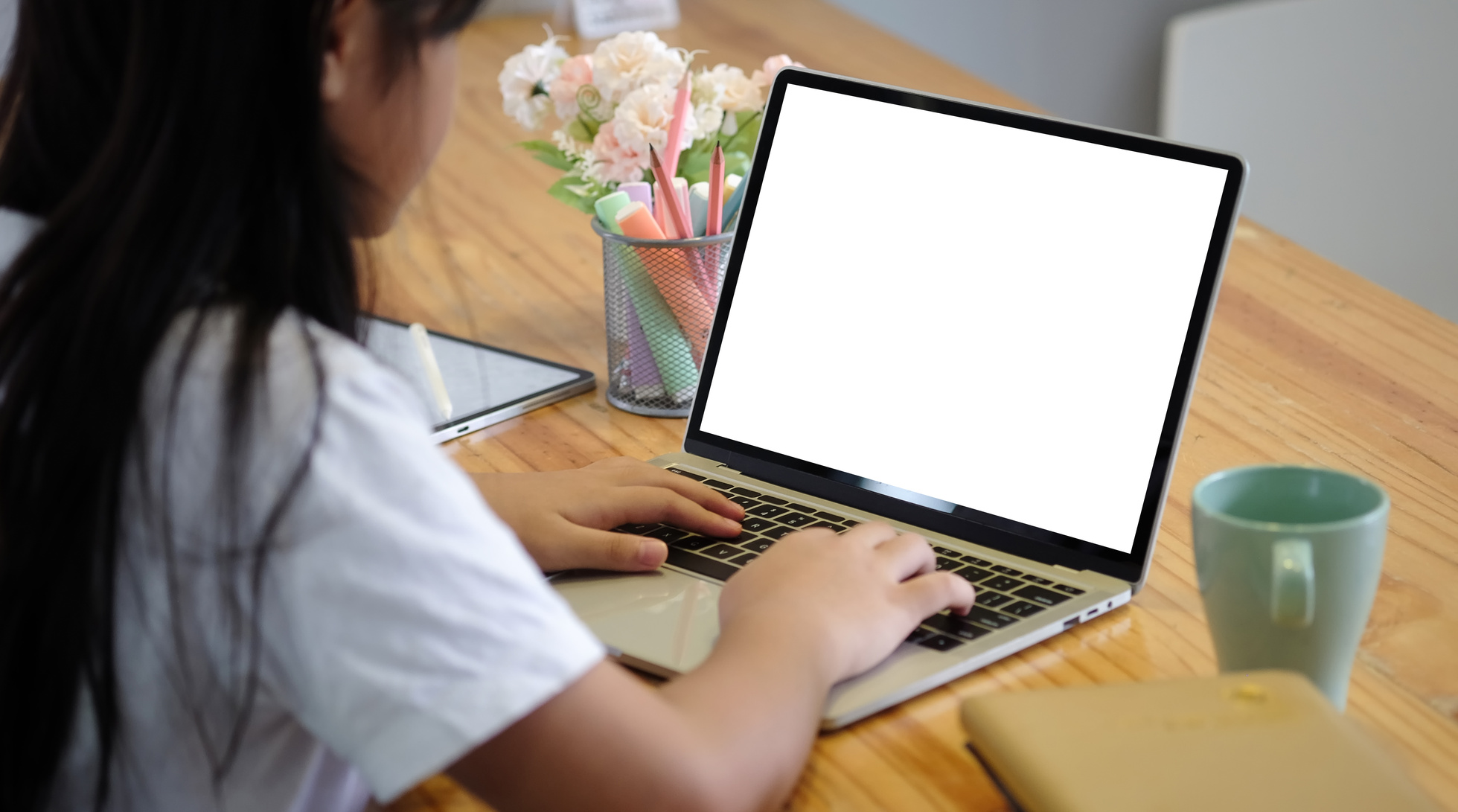 Woman Working on Laptop with Blank Screen on Table